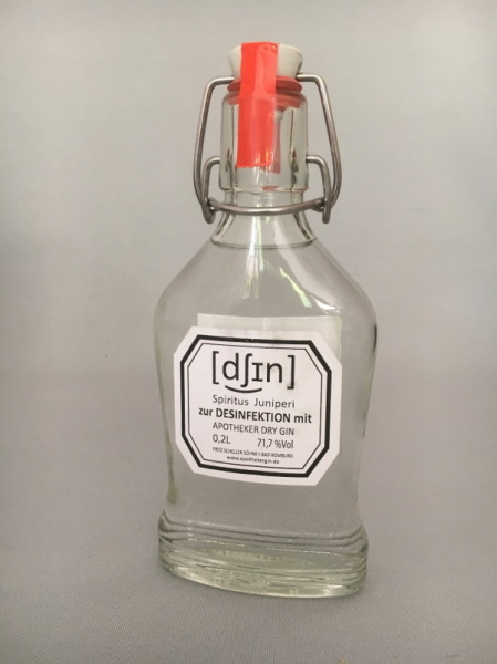 gefüllte Bügelflasche, Beschriftung des Etiketts: [dsin] Spiritus Juniperi zur Desinfektion mit Apotheker Dry Gin 0,2L 71,7%Vol