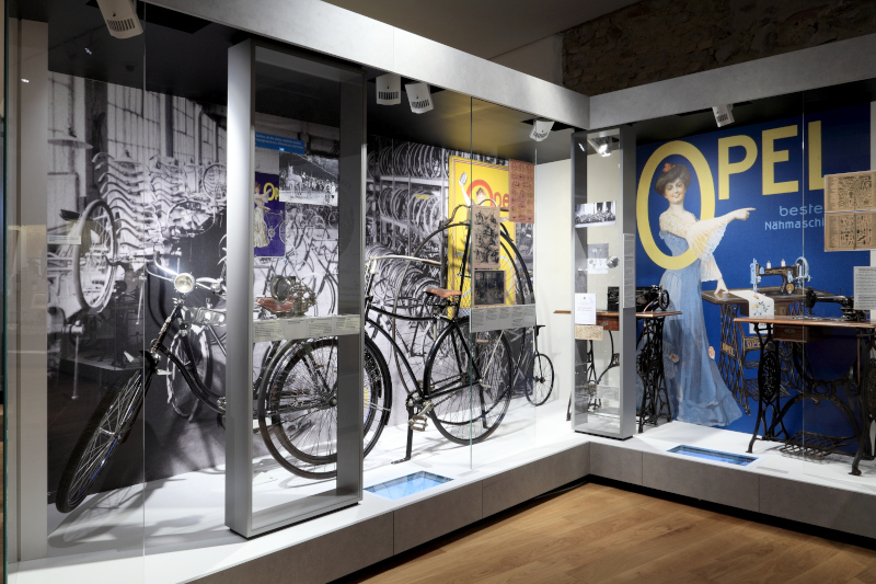 Museumsvitrine mit Fahrrädern der Marke Opel