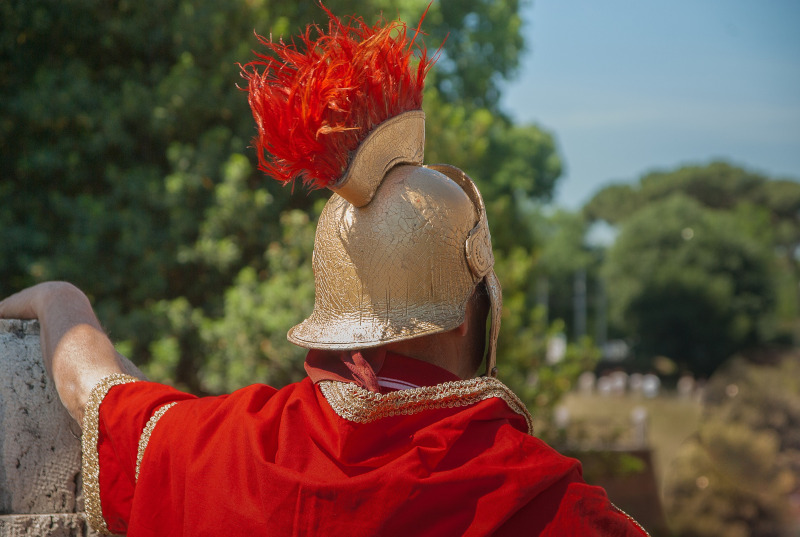Foto eines Mannes in Gewandung eines römischen Legionärs von hinten.